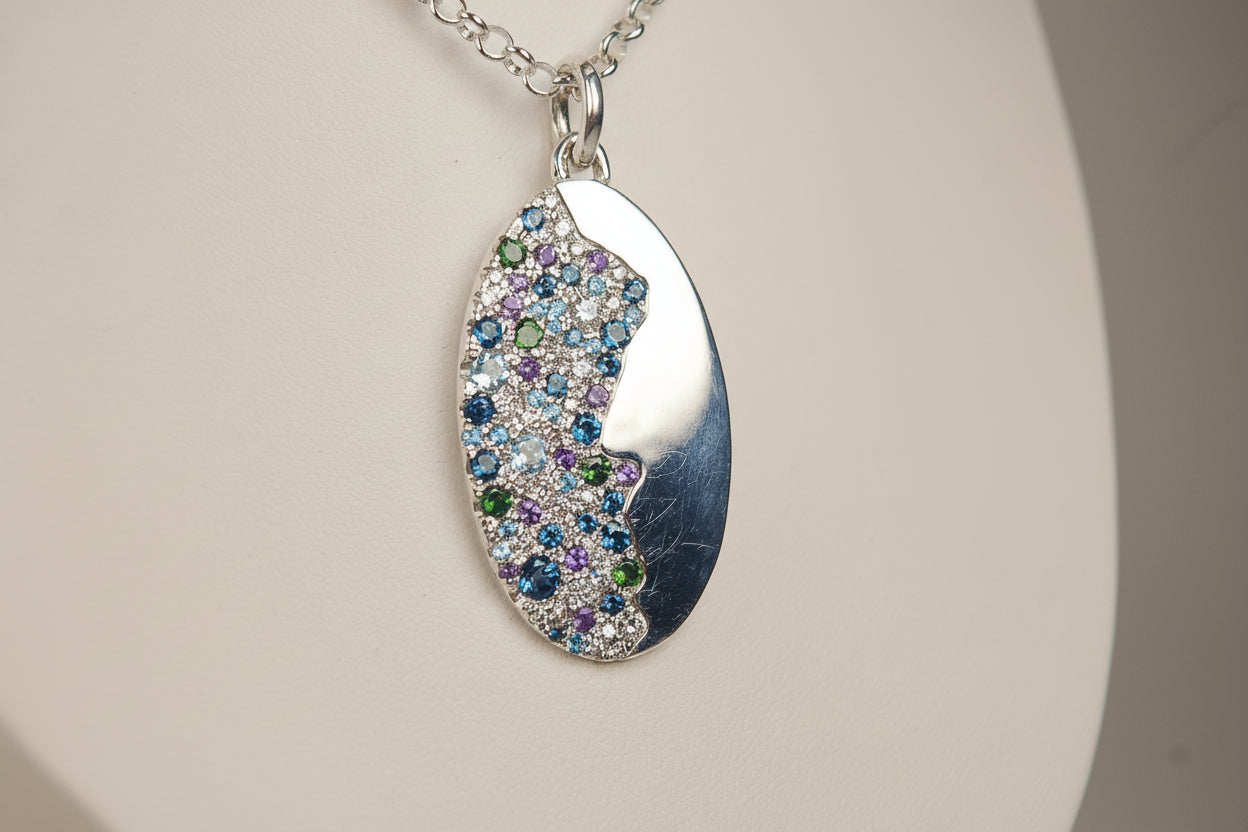 Silver necklace with a multicolored gemstone pendant on a light gray background